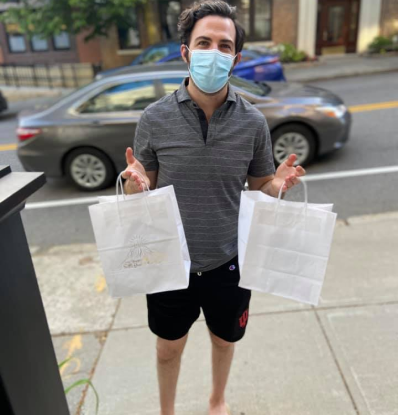 Image of man holding bags, bringing food to people in need